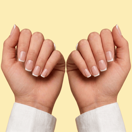 A close-up of two hands with neatly manicured French tip nails, shown against a solid pale yellow background.