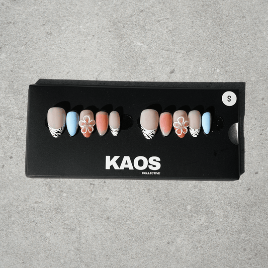 Box of 'KAOS Collective' nail art designs on a gray surface