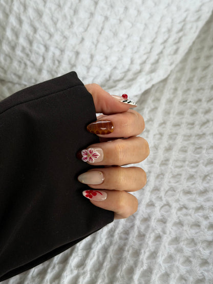 A hand wearing abstract press on nails on a white background