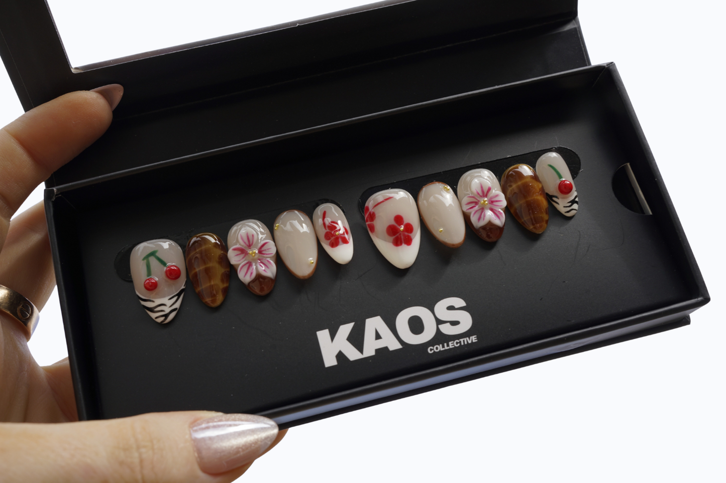 Set of decorative nails in a black box with 'KAOS Collective' branding.