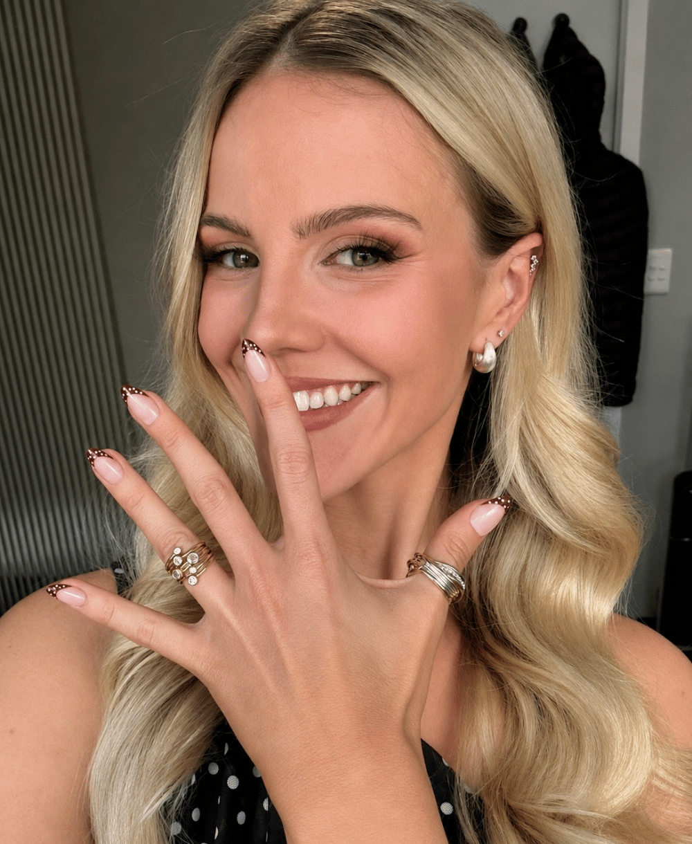 A girl with blonde hair showing her polkadot press on nails