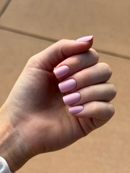 A hand wearing pink square press on nails