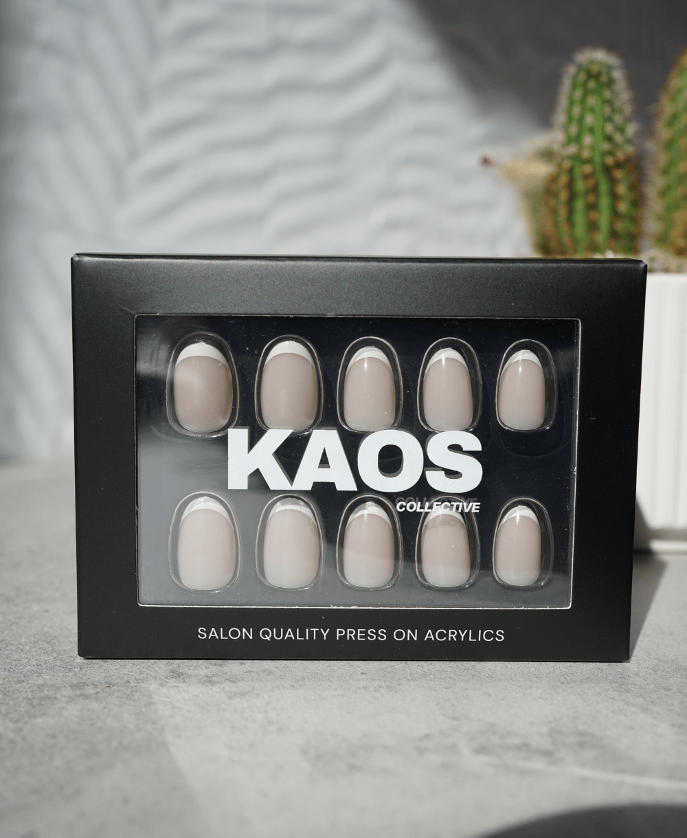 Box of press-on acrylic nails with 'KAOS Collective' branding on a neutral background.