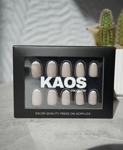 Box of press-on acrylic nails with 'KAOS Collective' branding on a neutral background.