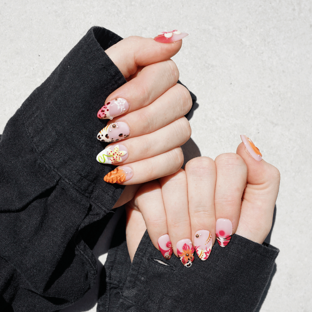 Close-up of hands with colourful nail art against a neutral background
