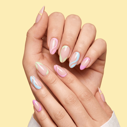A close-up of 2 hands with manicured almond-shaped nails featuring pastel pink, mint green, and light blue marble swirl patterns, set against a solid pale yellow background.
