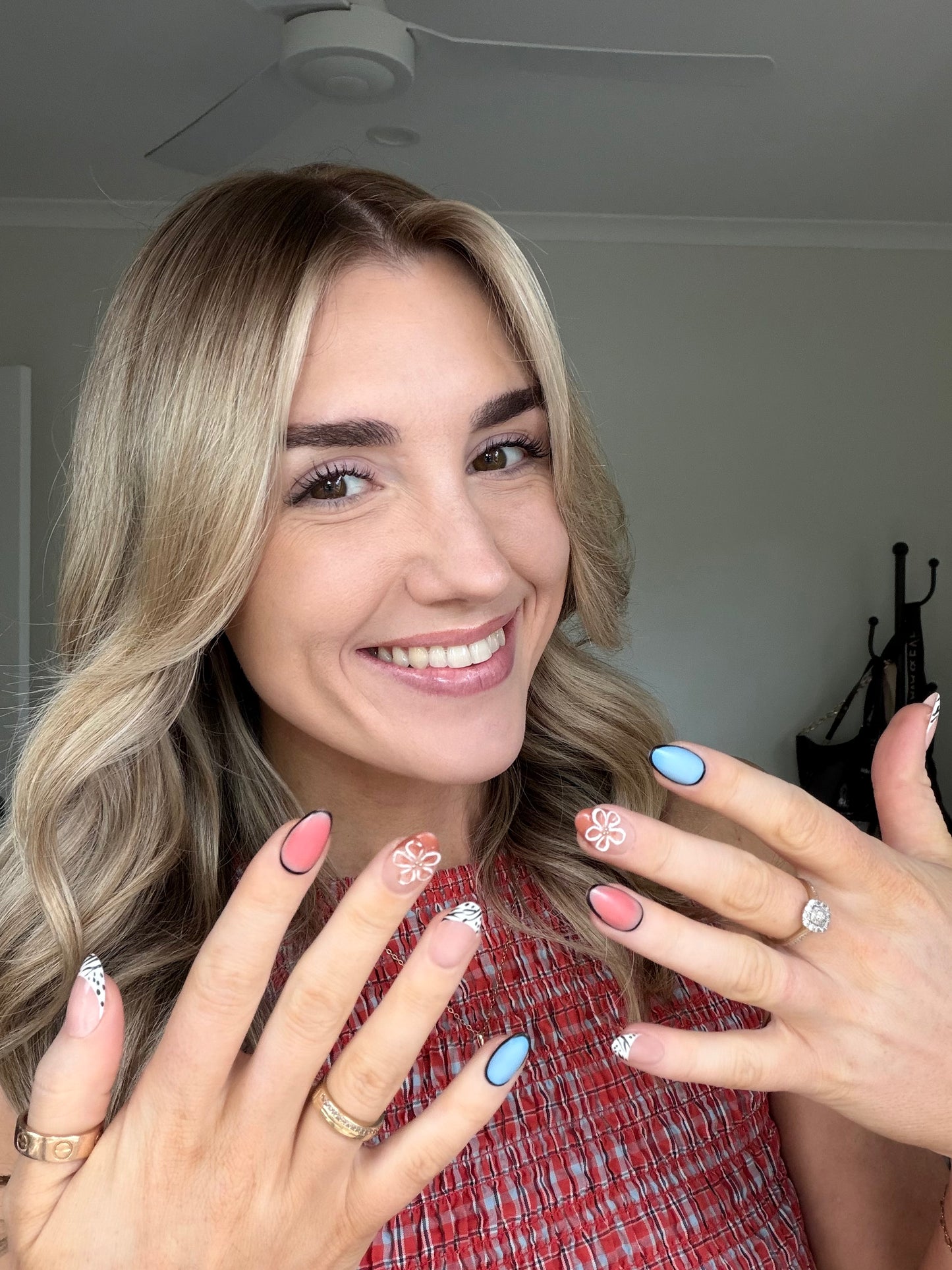 A woman wearing colour press on nails in a red top