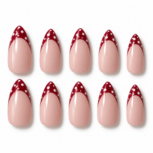 Ten false almond-shaped nails arranged in two rows on a white background, featuring a glossy pale pink lower section and a deep red pointed tip with white polka dots.