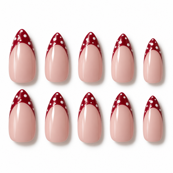 Ten false almond-shaped nails arranged in two rows on a white background, featuring a glossy pale pink lower section and a deep red pointed tip with white polka dots.